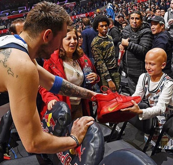Luka Doncic Giving Shoes To a Child